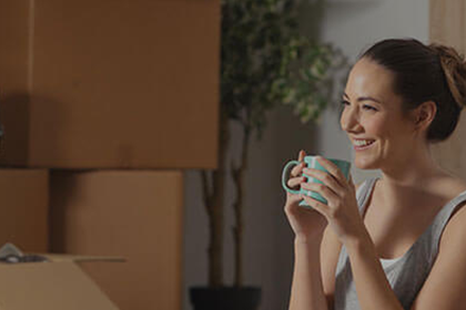 Women drinking from mug after moving in